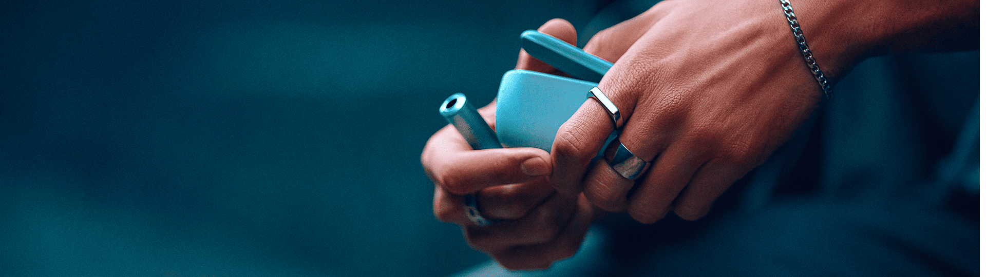  A person holding an IQOS ILUMA i prime Color Midnight Black